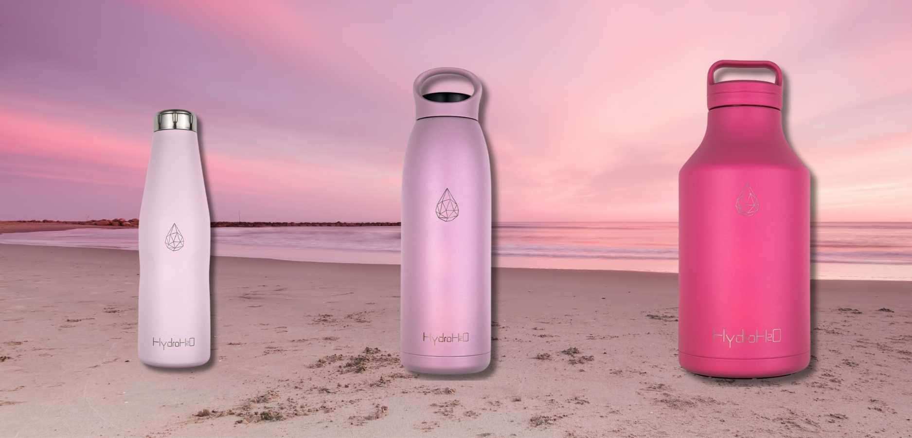 HydroH2O_Stainless_Steel_Water_Bottle_Sunset_Inspired_Pink_Bottles_On_Sunset_Background